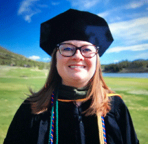 Woman with glasses and phd graduation cap and gown.