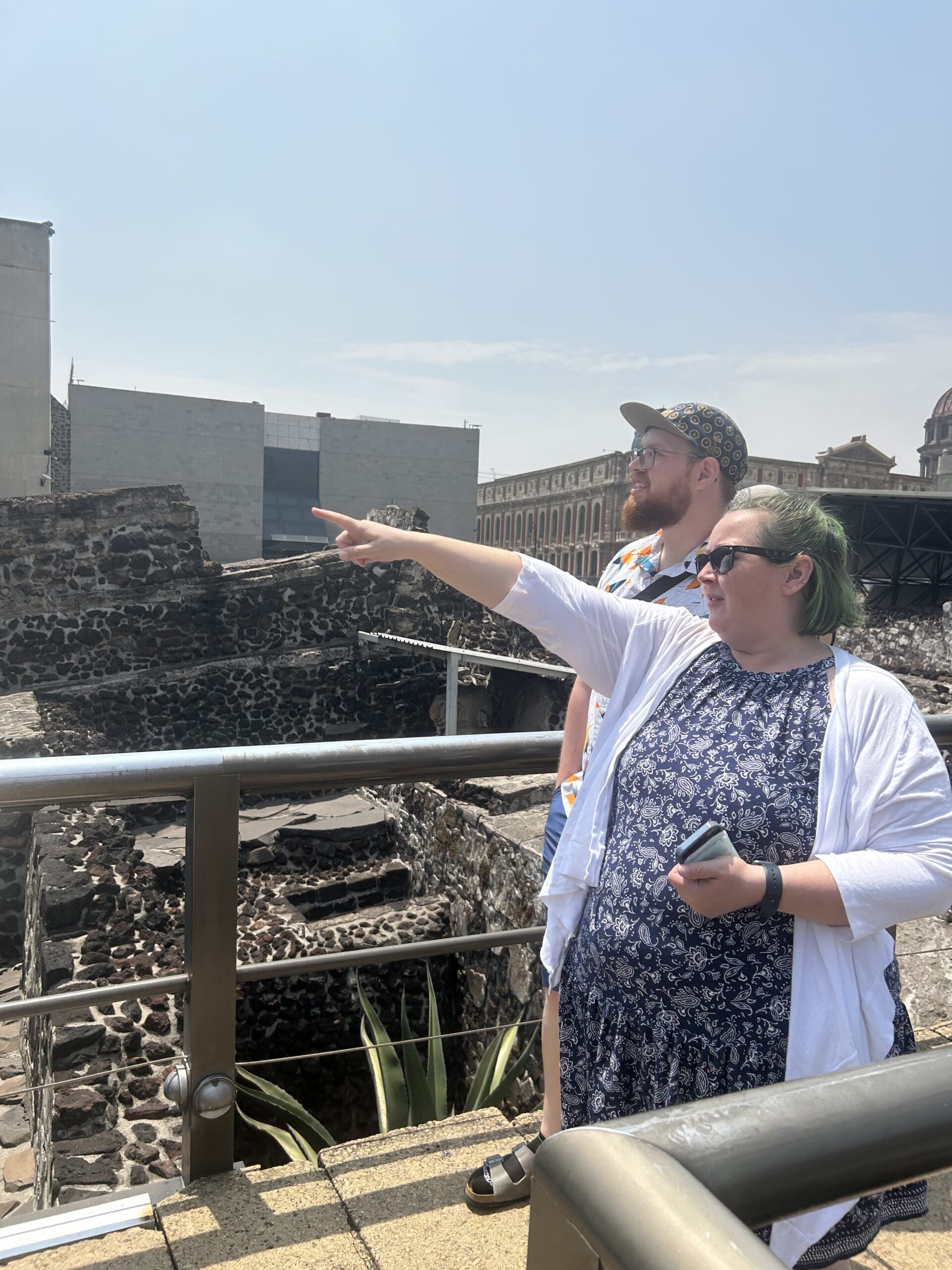 Two people at an archaeological site pointing.
