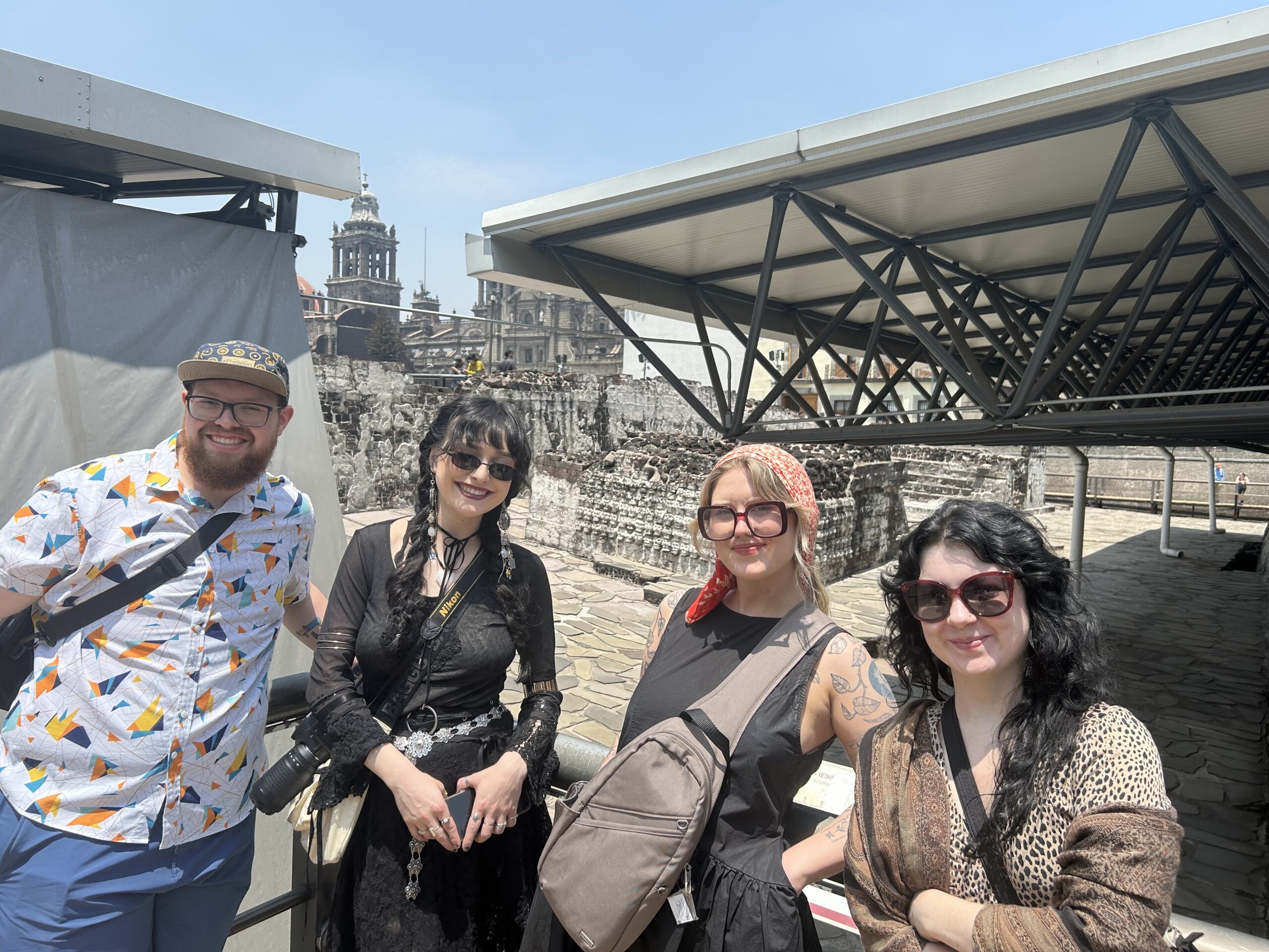 Four people at a temple ruins site.