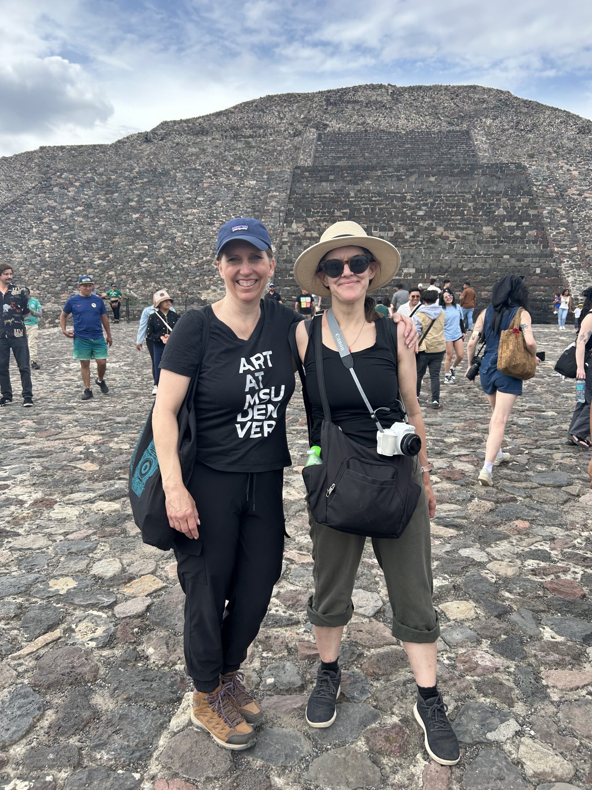 Two people at a pyramid ruins site.