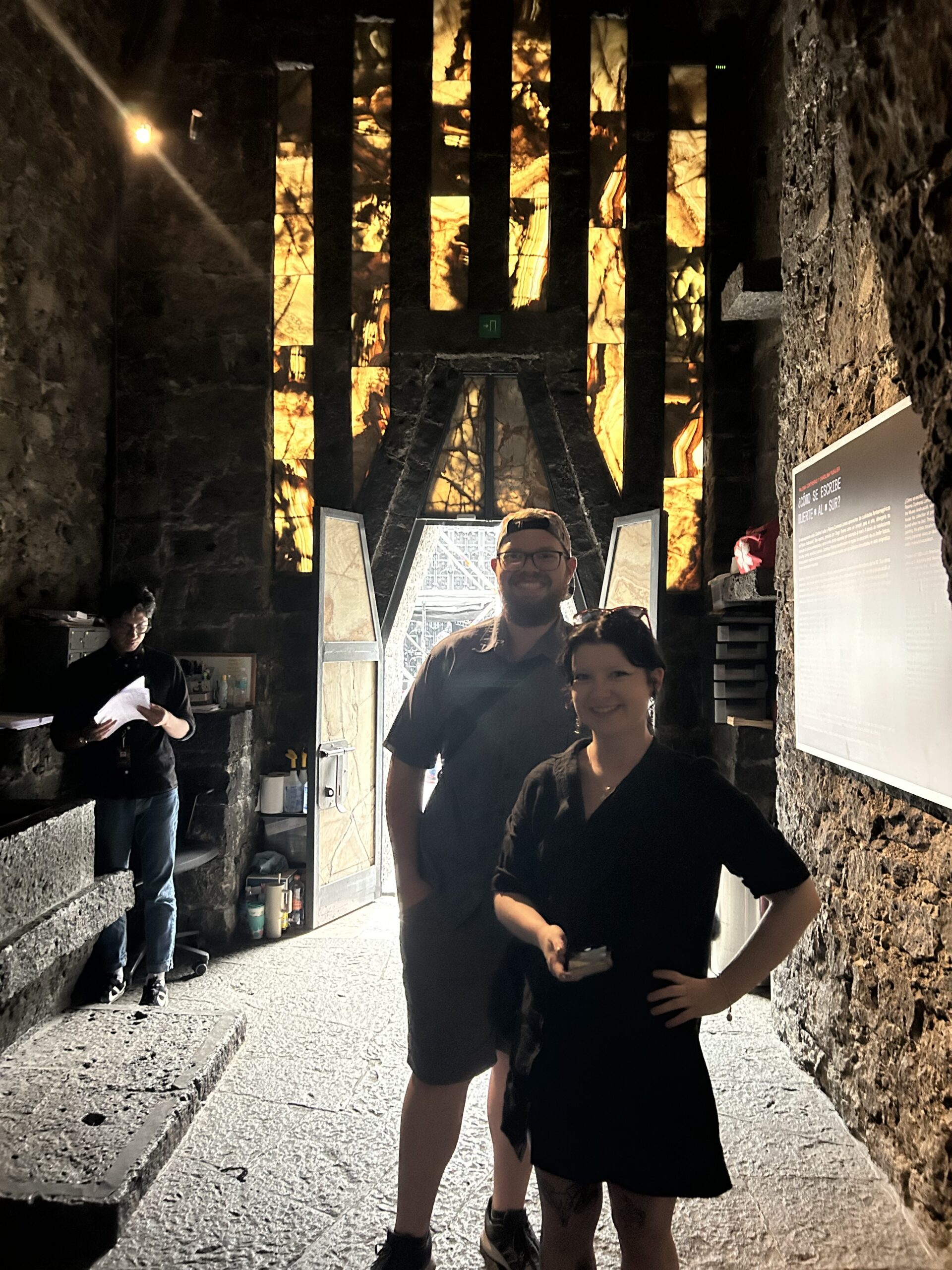 Two people with stained glass behind them.
