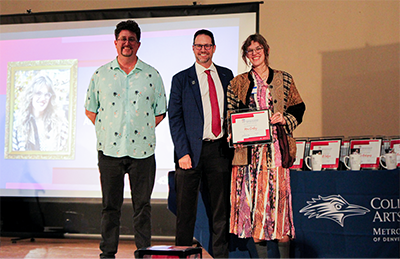Art Department Chair Matt Jenkins and Dean John Masserini award certificate to Mia Conley