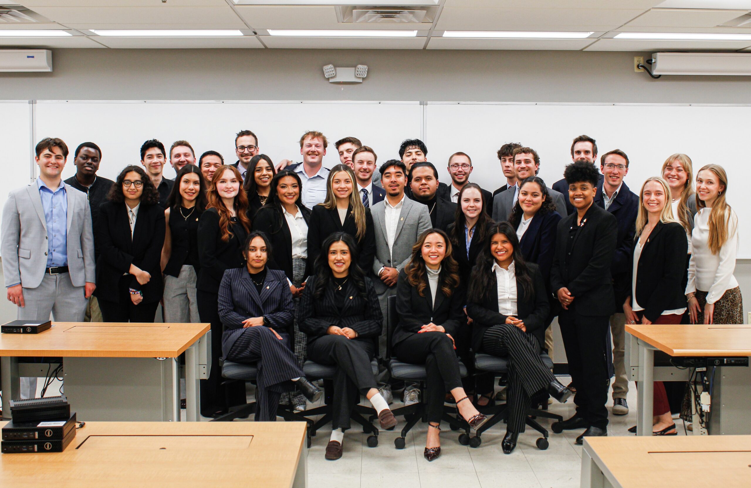 A large group of students in professional attire posing formally for a portrait during an MSU Denver PSE initiation night.