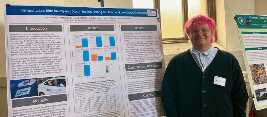 A student with pink hair and glasses presenting a poster on "Transportation, Ride-hailing and Discrimination Among the Blind and Low Vision Community"