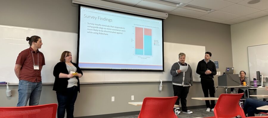 Four people giving a Powerpoint presentation