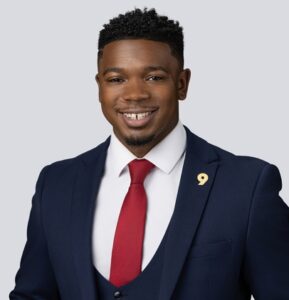 male in a blue suit and red tie