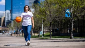 Brianna Bailey walking on campus holding a basketball