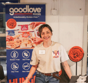 Woman stands in front of a goodlove Foods sign