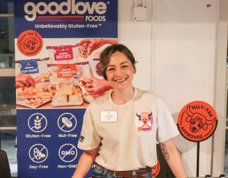 Woman stands in front of a goodlove Foods sign