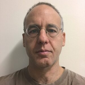 A man with short gray hair and glasses