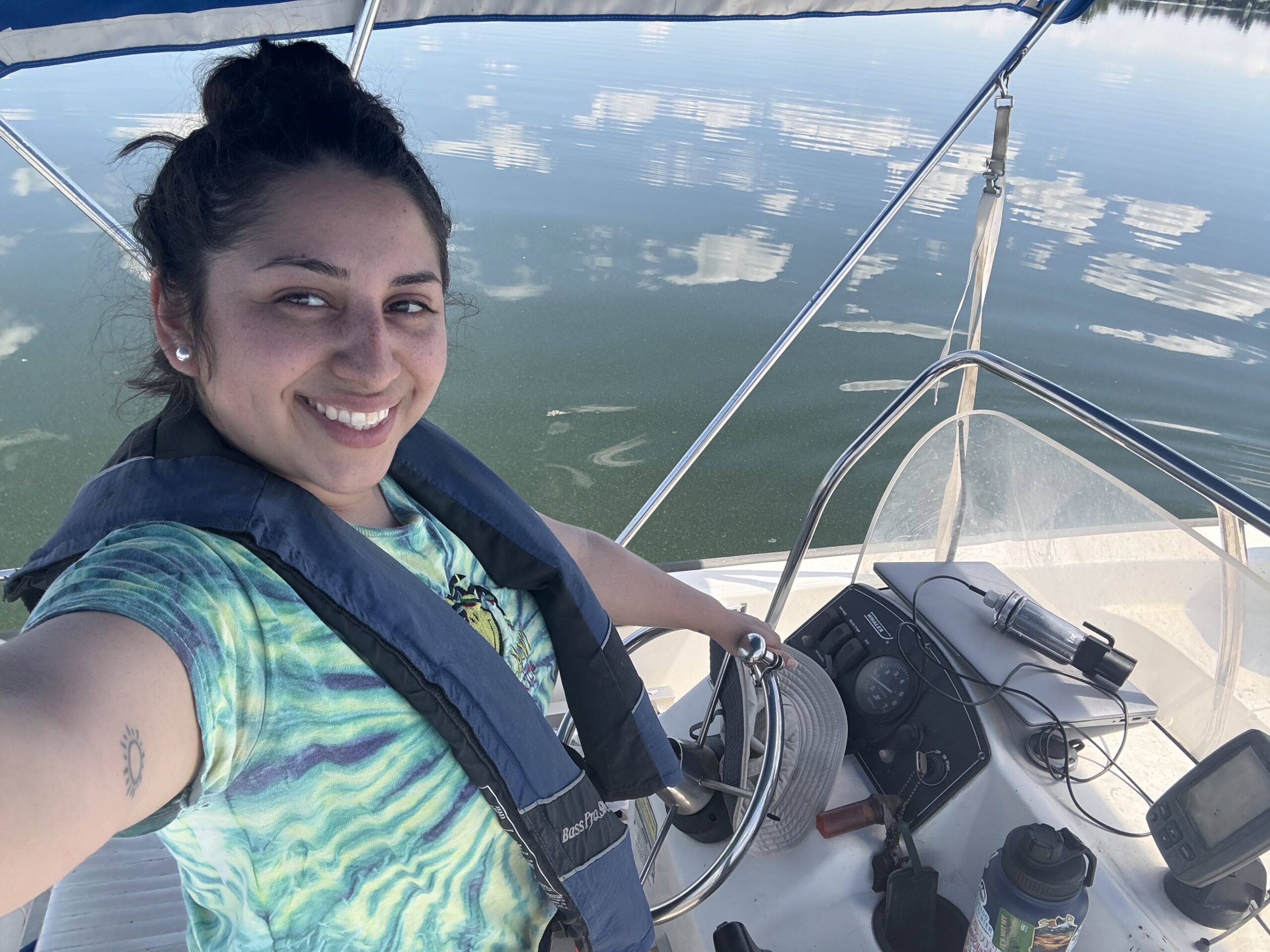 Women wearing a green shirt while driving a boat