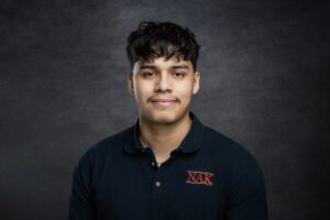 Student wearing a black polo smiling