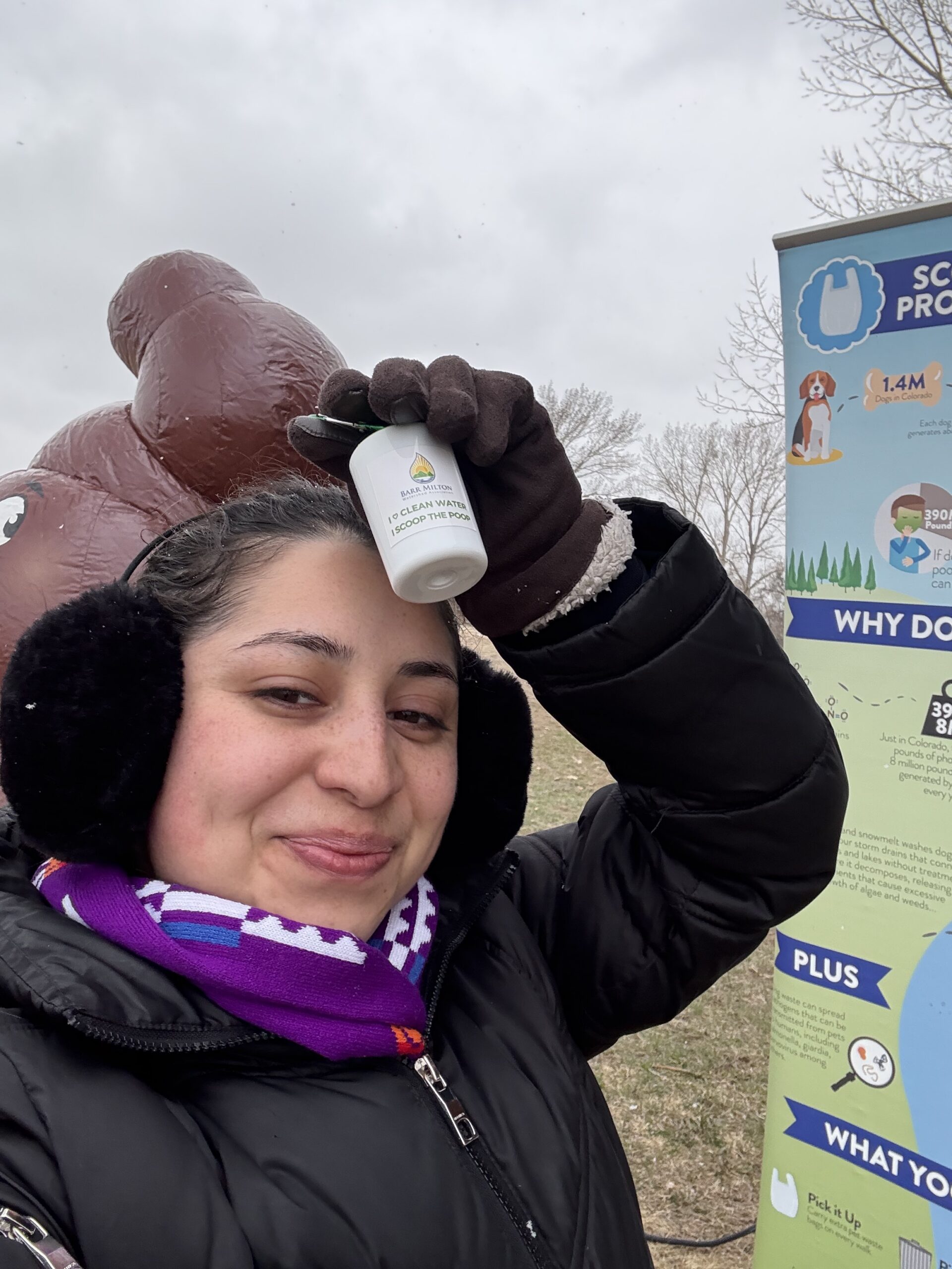 Girl wearing cold weather clothing smiles while holding a white bottle