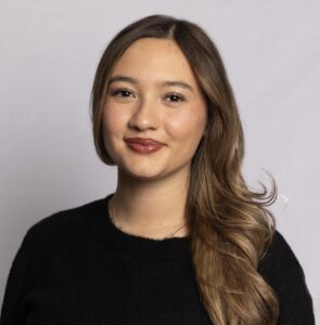 Headshot of a woman with brunette hair and a black shirt