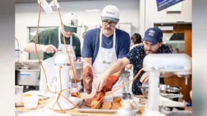 MSU Denver student Ryan Evans turns a pan upside down to release his cupcakes as Stephen Barela of the School of Hospitality steps in to assist.