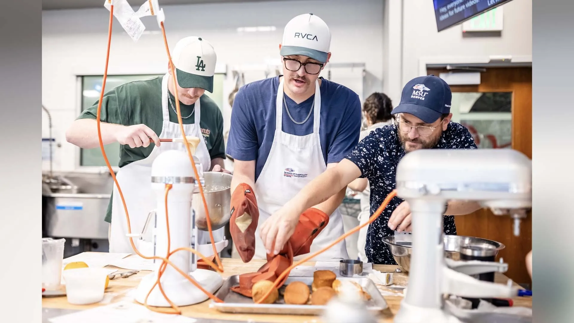 MSU Denver student Ryan Evans turns a pan upside down to release his cupcakes as Stephen Barela of the School of Hospitality steps in to assist.