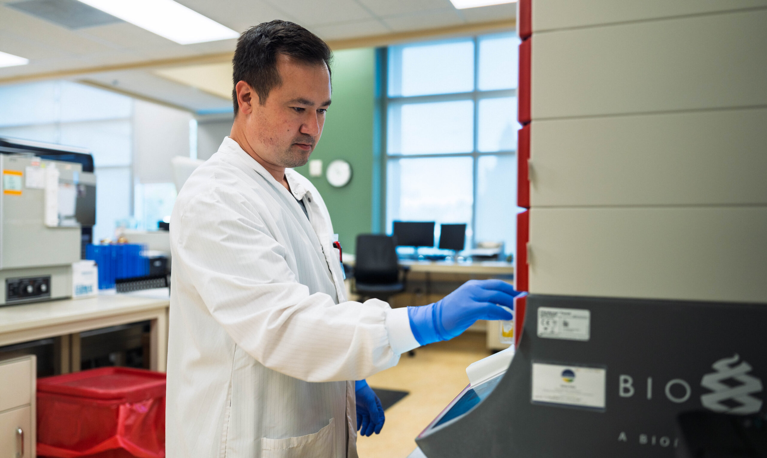 MLS in a white lab coat interacting with a medical device.