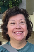 Woman with short dark hair smiles at the camera