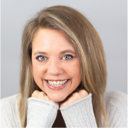 Woman with long blonde hair rests her chin on her hands