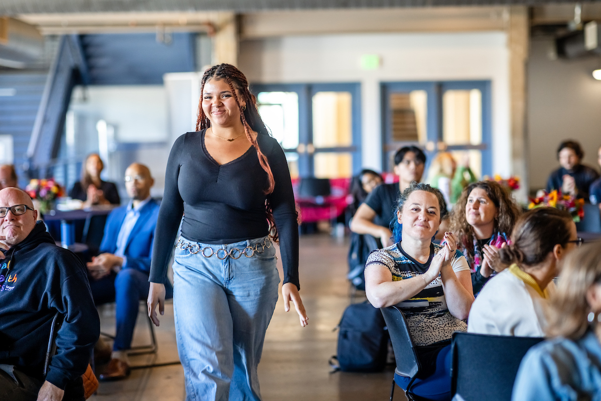 CHHS Peer Mentor and Criminal Justice & Criminology student Kayla Feldon walking up to receive her Outstanding Student Employee Award in the Tivoli Turnhalle on 9/24/25. Photo: Alyson McClaran