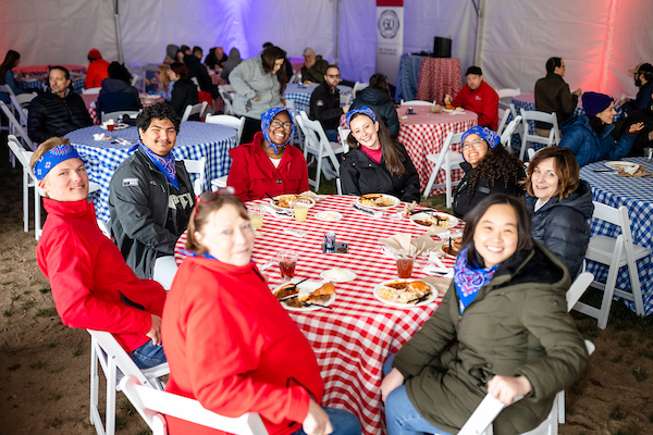MSU denver staff and faculty smile for the camera as they are gathered around a table