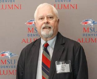 Paul Larson in a black jacket and blue and red tie