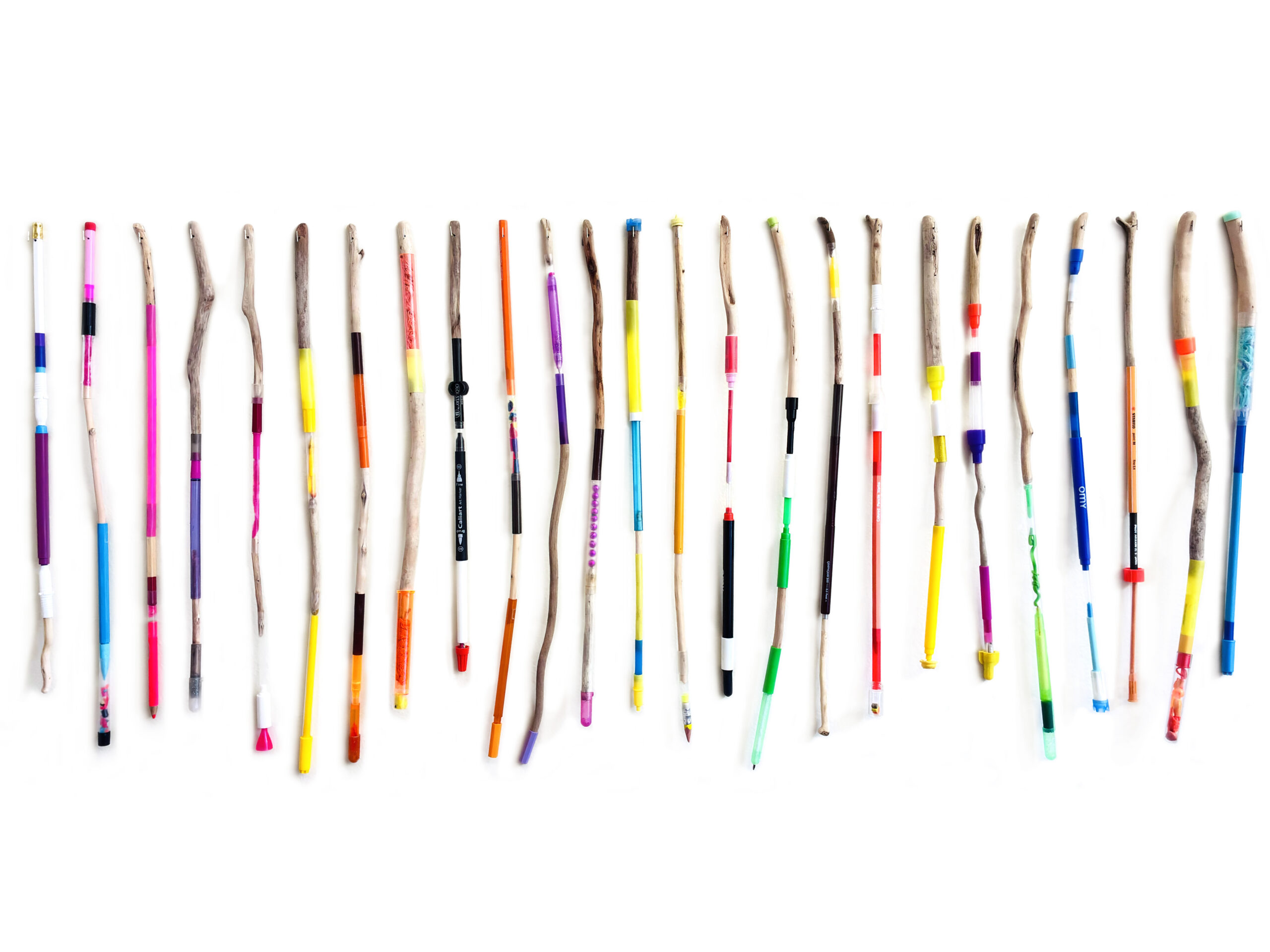 A collection of colorful painted sticks aligned in a row on a white background.
