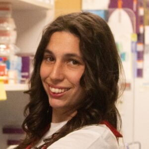 A woman with long wavy brown hair standing in a laboratory