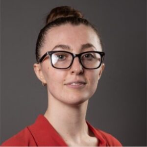 A woman with her brown hair in a bun wearing glasses