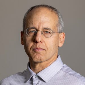 A man with short gray hair wearing glasses and a button down shirt