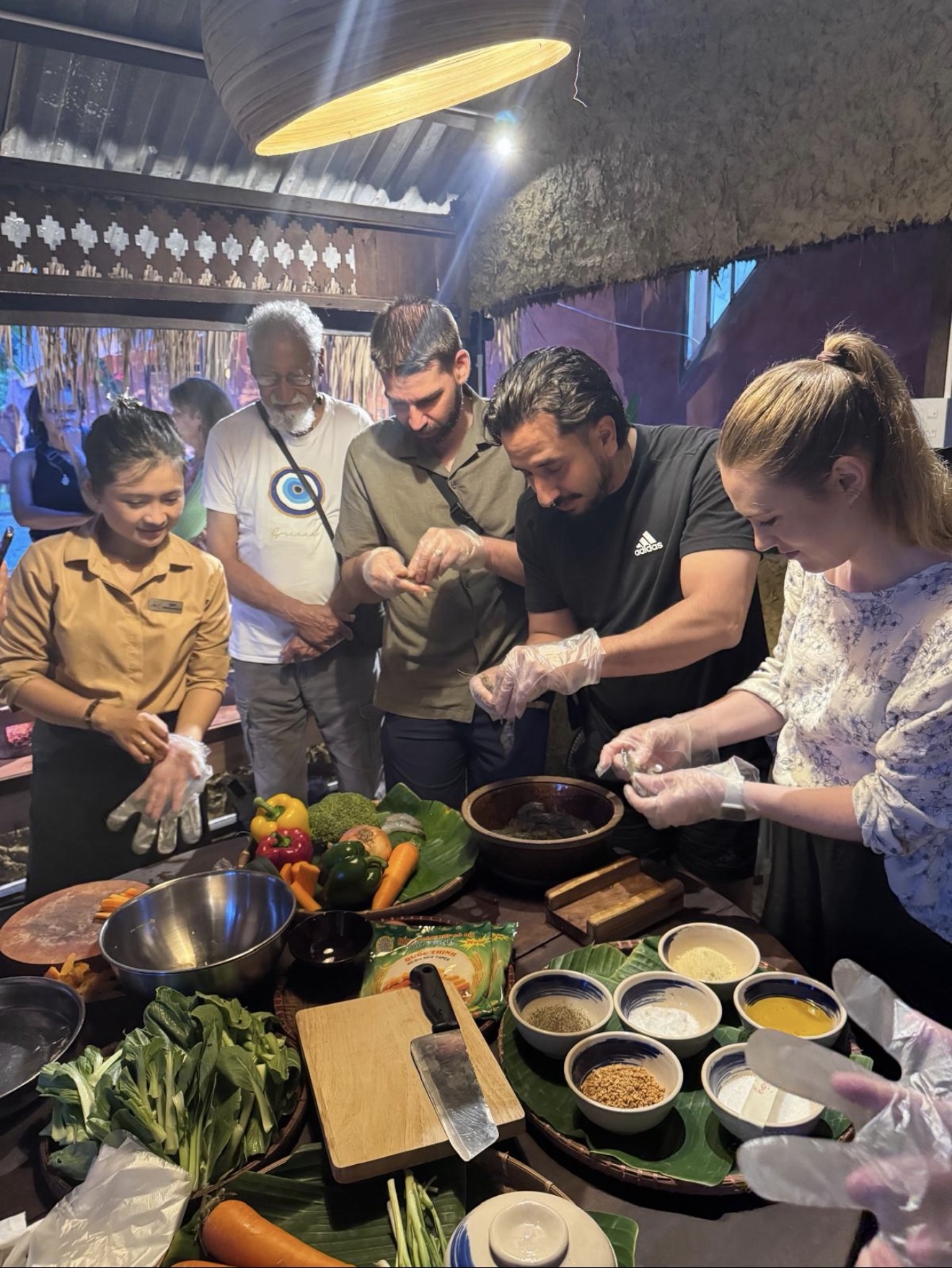 Students learning how to cook Vietnamese dishes like spring rolls.