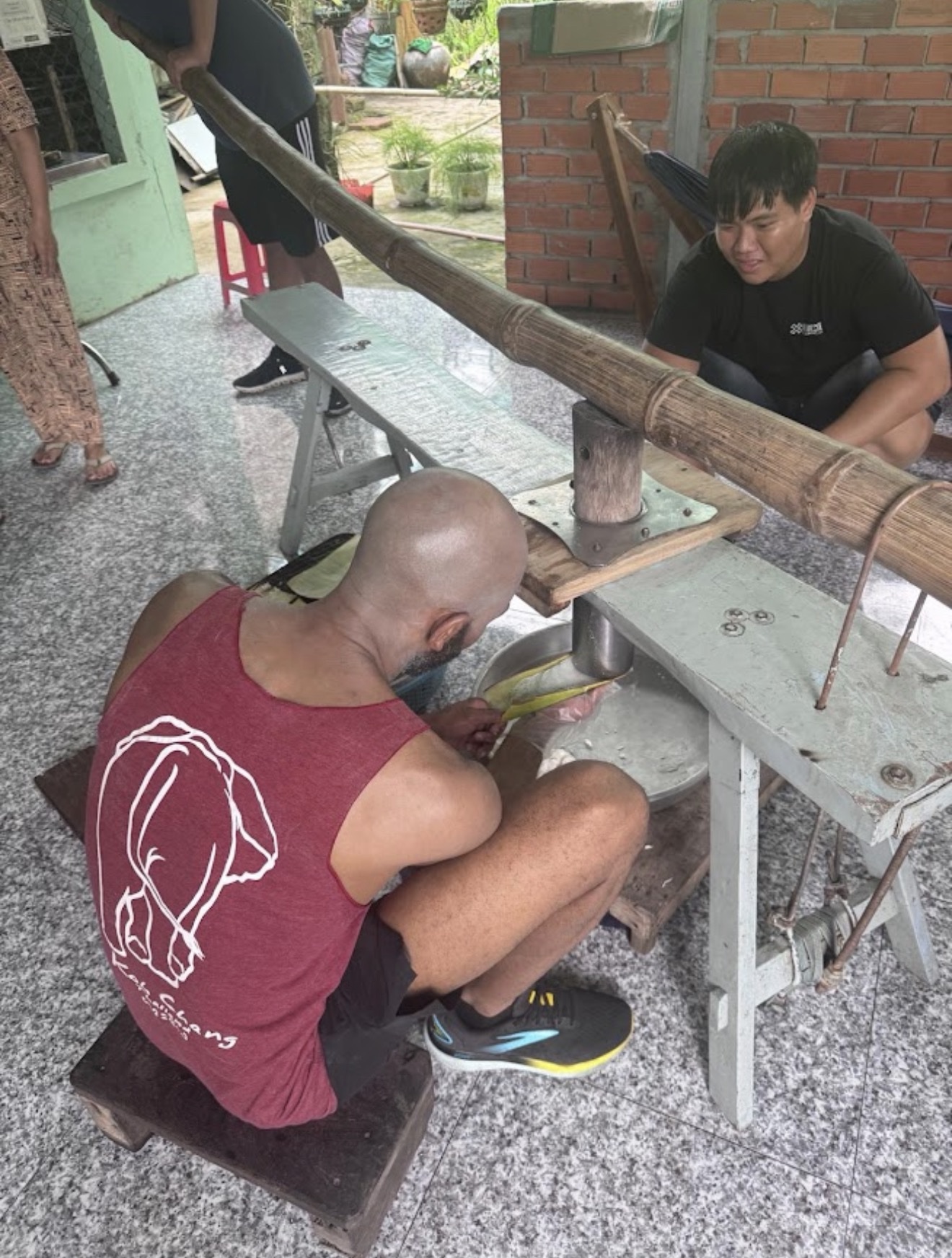 Ron learning how to make rice noodles in Vietnam using a special tool.