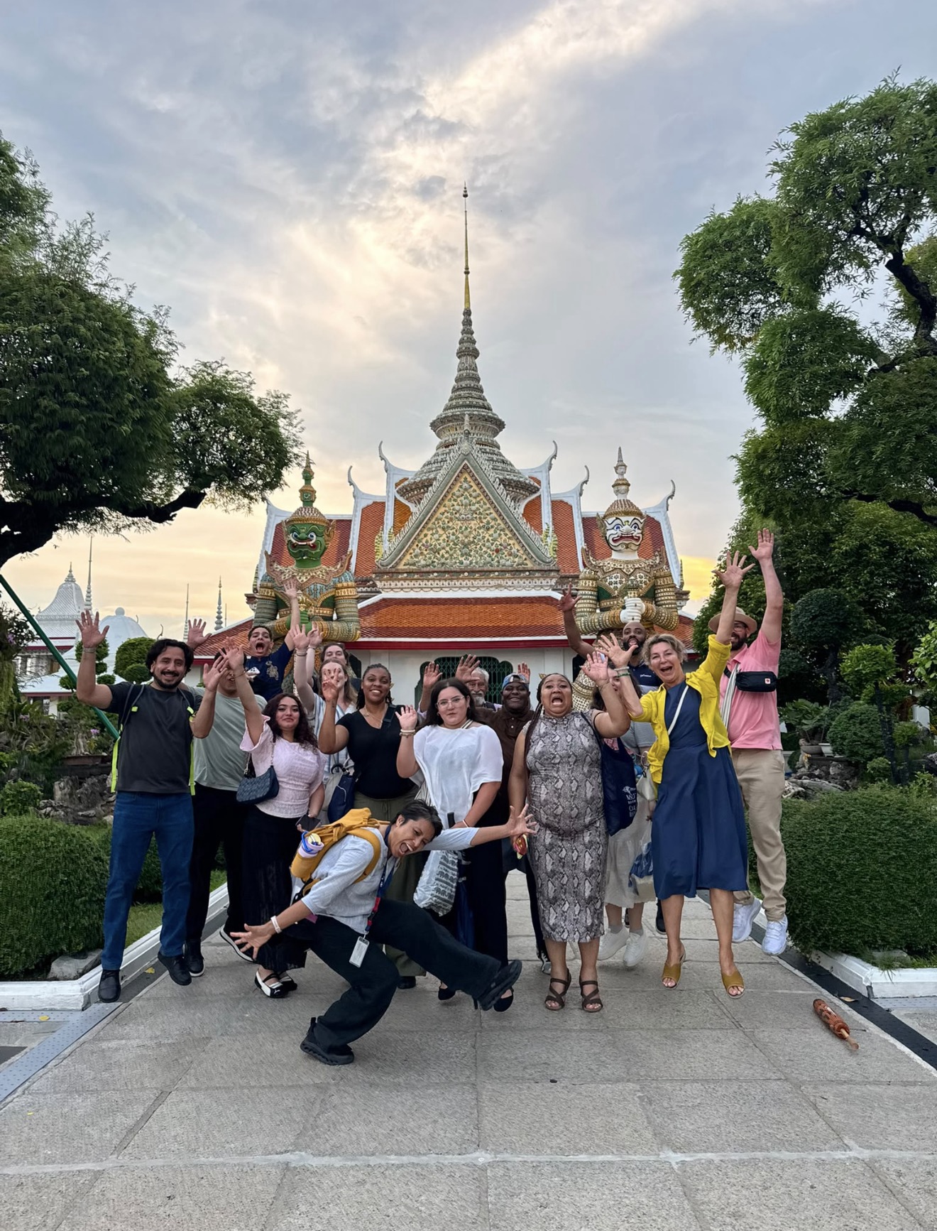 Group selfie of the study abroad group in front of a temple jumping and smiling.