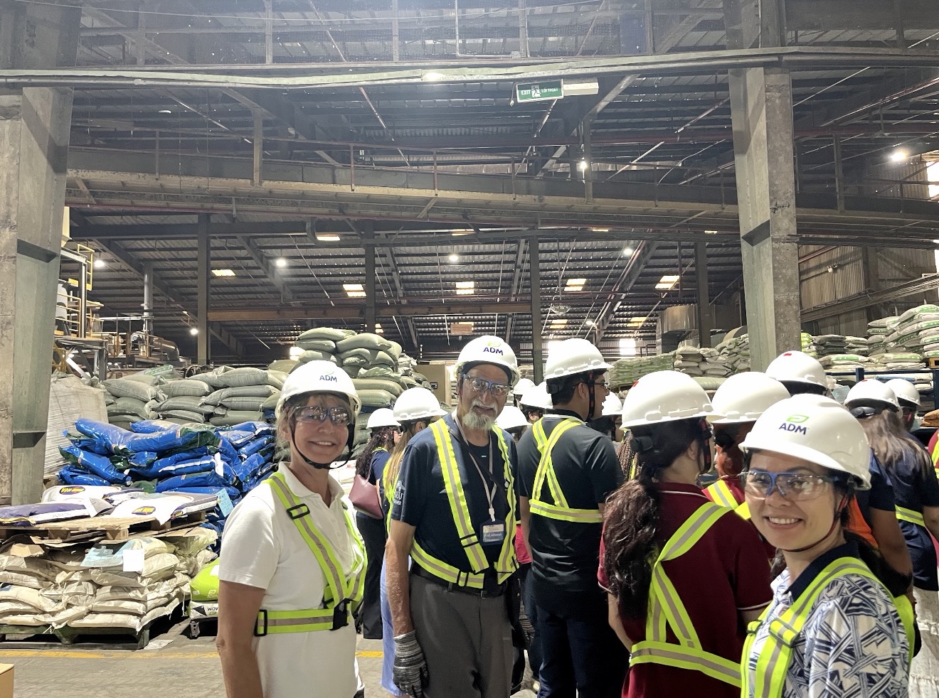 Group picture of the professors wearing caps in a business factory.