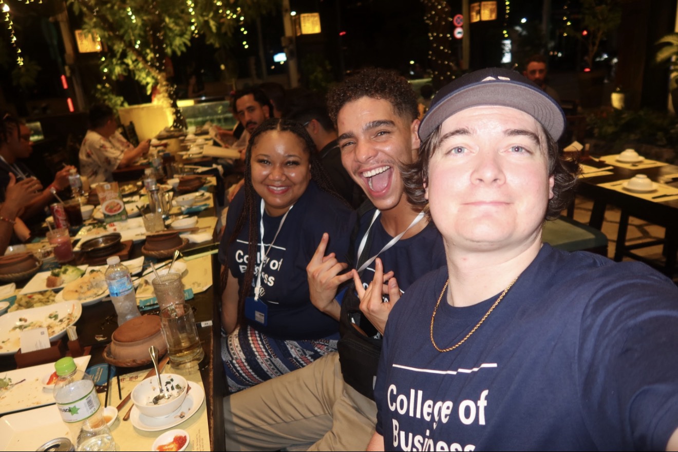 Group selfie of students smiling at a restuarant in Vietnam.