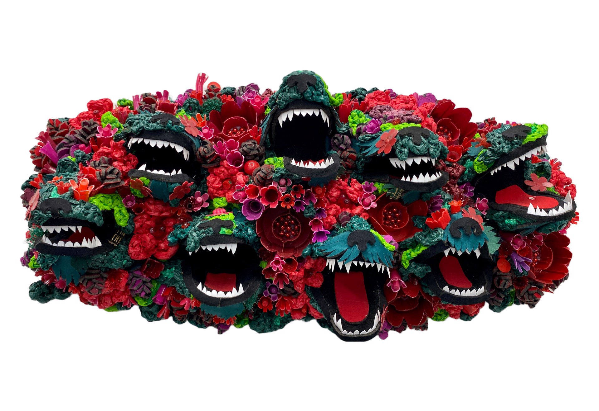 A colorful sculpture featuring stylized wolf heads with open mouths surrounded by red and pink flowers.