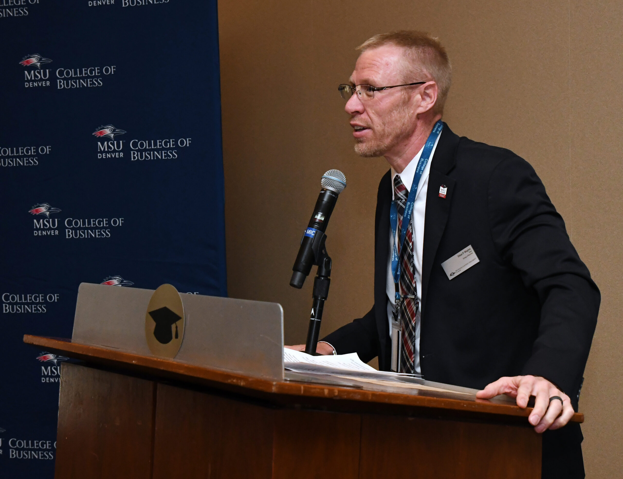 Dean Waples talking at the podium at Spring '26 MBA & MPAcc Hooding Celebration