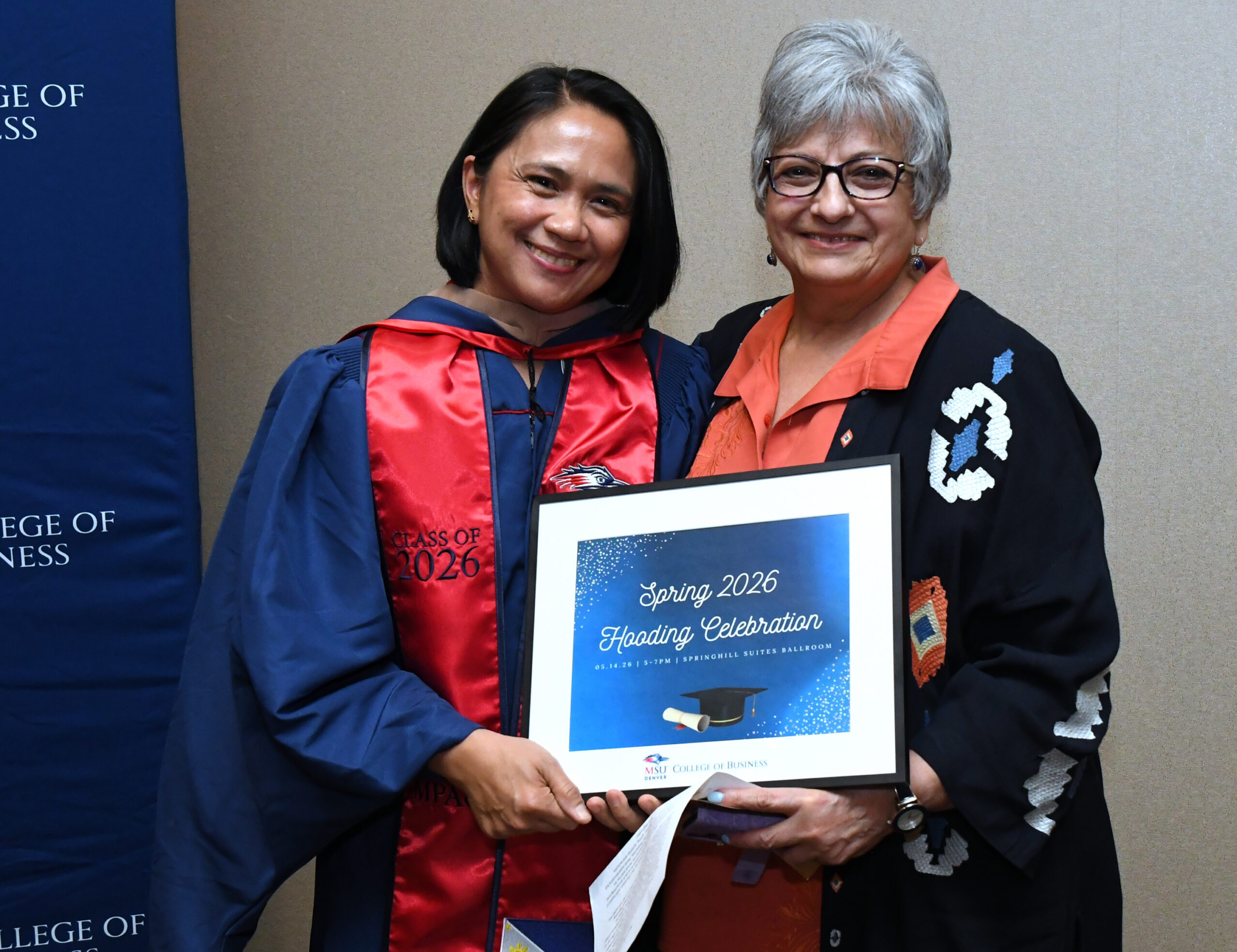 MPAcc grad, Marie, and faculty, Sheri, smile at camera at SP'26 MBA & MPAcc Hooding Celebration