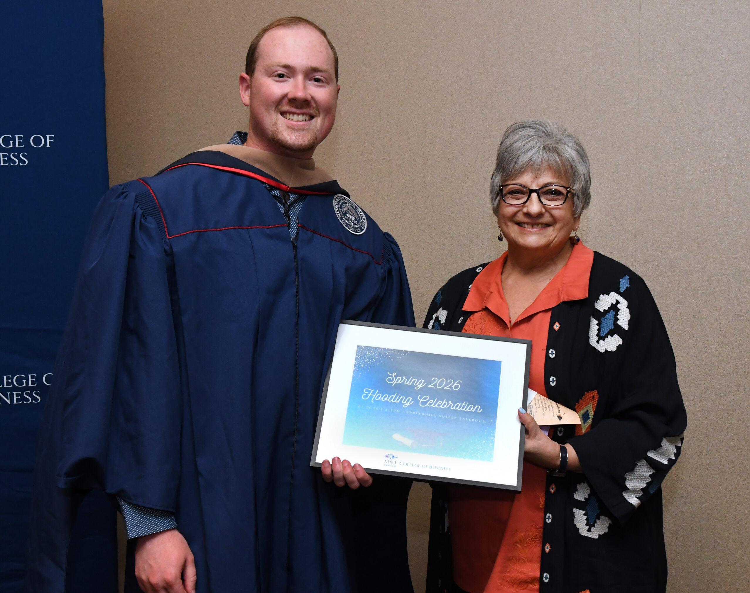 MPAcc grad, Joshua, and faculty, Sheri, smiling at SP'26 MBA & MPAcc Hooding Celebration