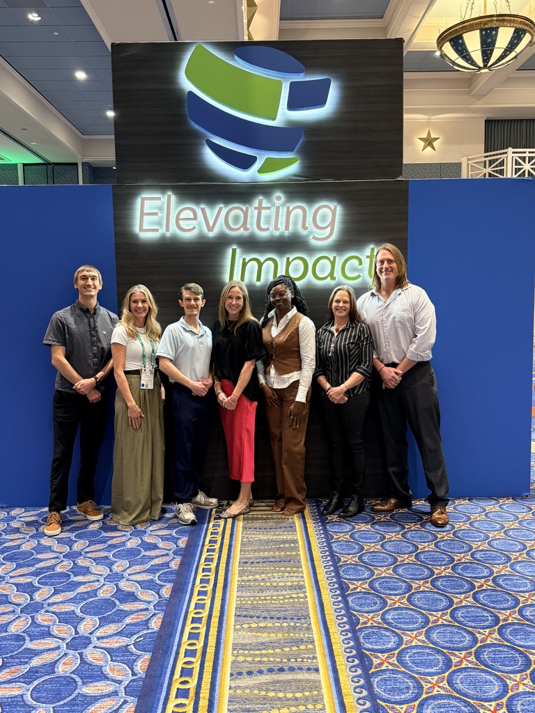 MPAcc students at IIA conference in front of sign