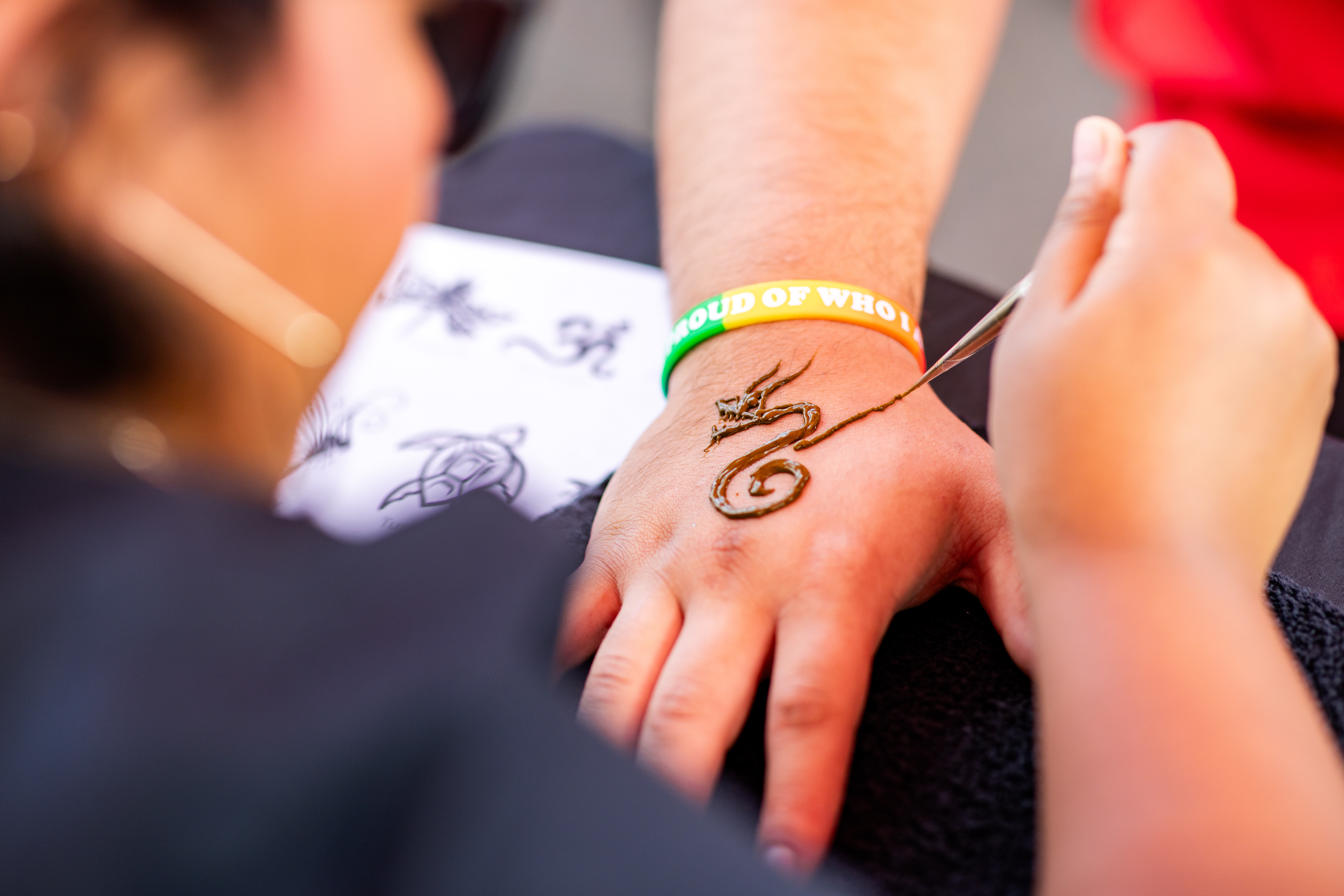 Convocation - attendee getting henna tattoo on back of hand