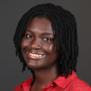 A black woman with shoulder length black hair wearing a red shirt