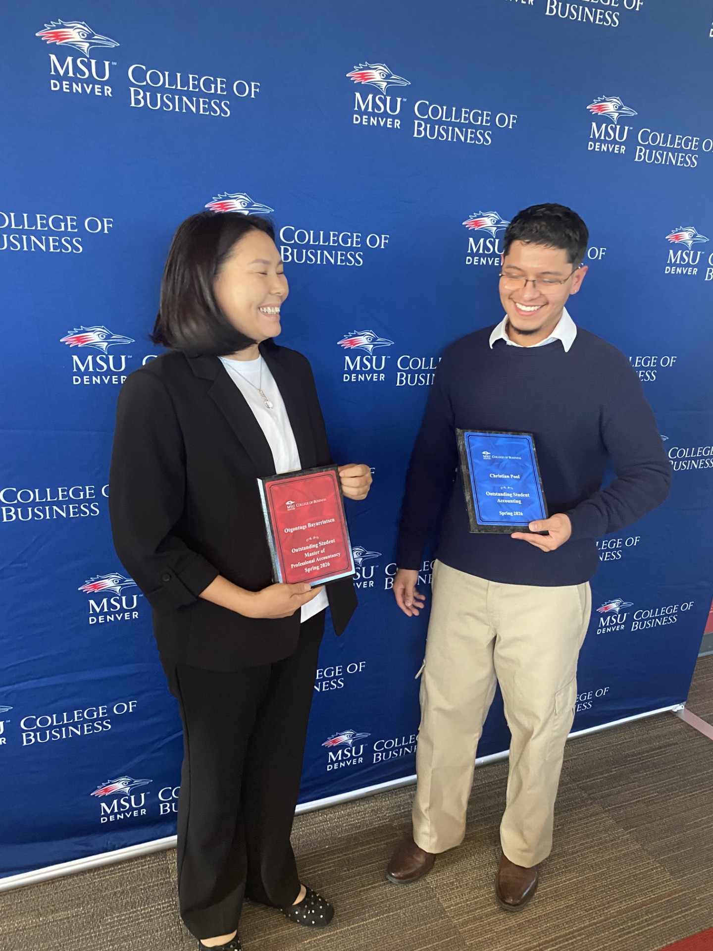 Spring '26 Outstanding Student Award recipients (Otgontugs for MPAcc, Christian for Accounting) smiling with their plaques