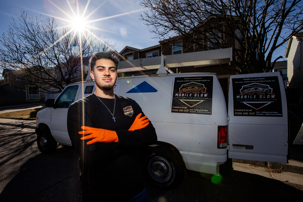 Student standing in front of his mobile business vehicle, Mobile Glow Automotive Detailing.