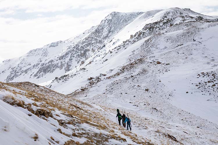 Backcountry skiers hiking to a mountain's summit.