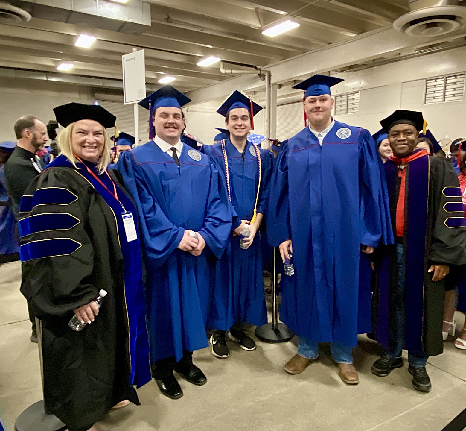leadership and faculty posing with a 3 accounting grads as they line up for SP'26 Commencement Ceremony