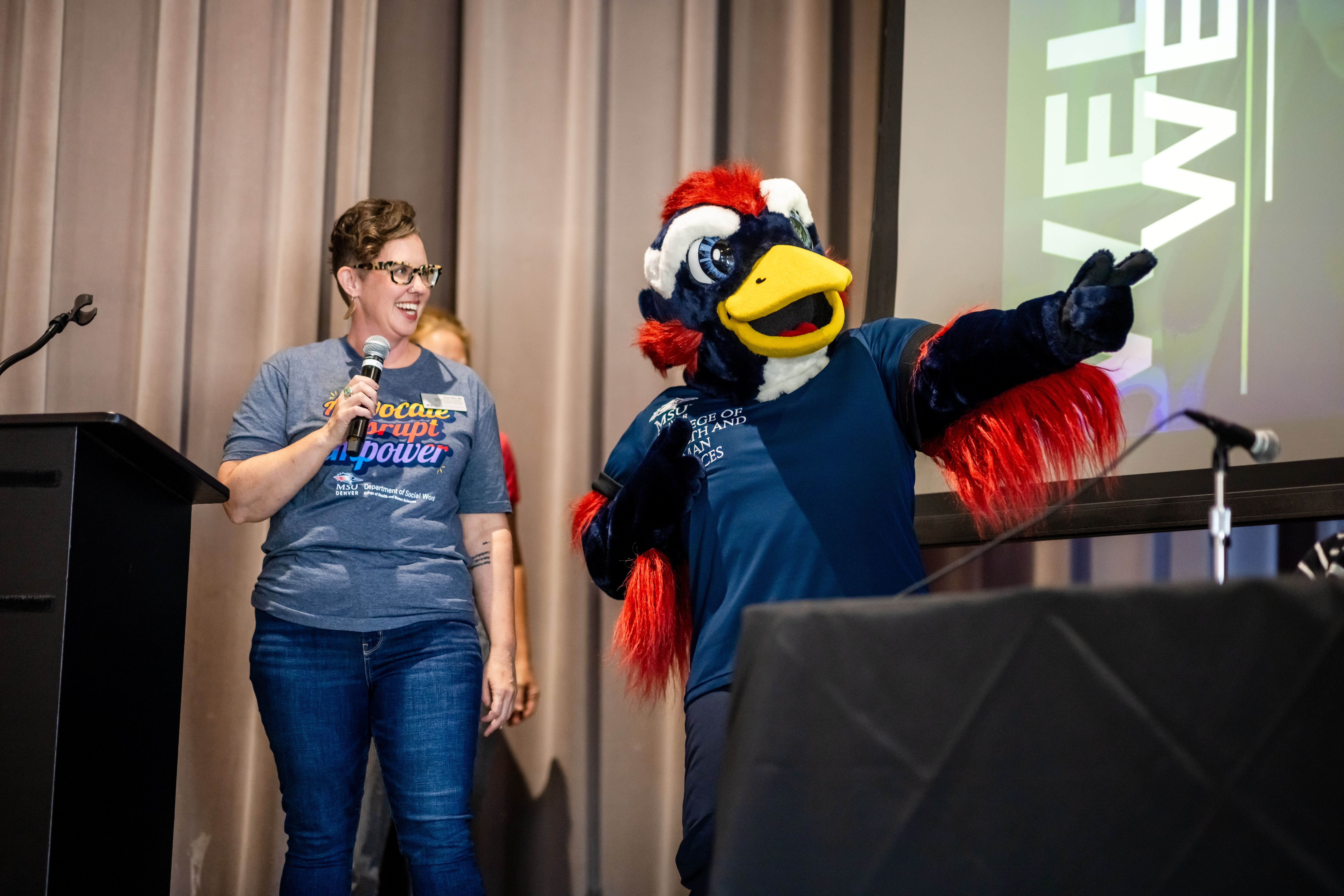 MSU Denver Rowdy pointing next to someone wearing an MSU Denver Department of Social Work t-shirt