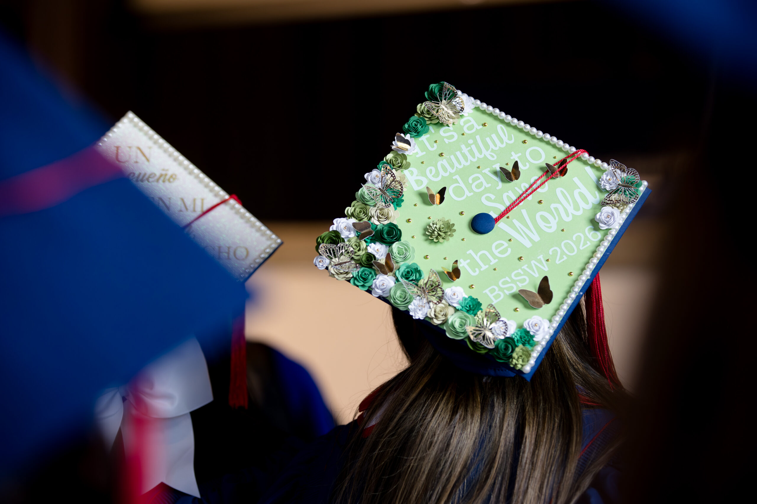 Graduation cap decorated with flowers and butterflies that reads, 
