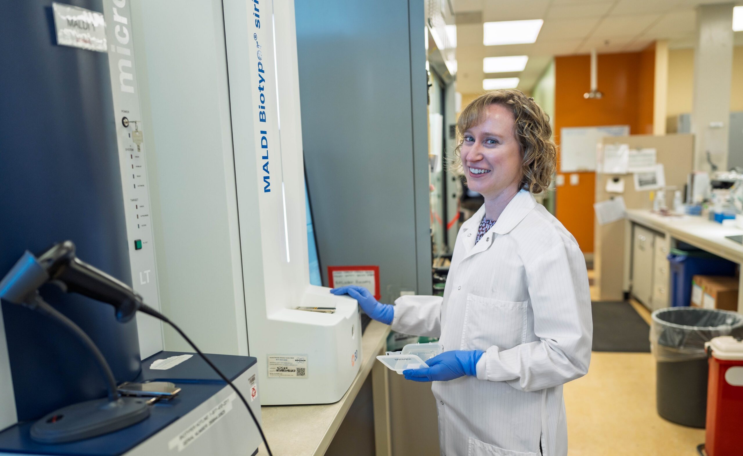 A laboratory scientist working in a hospital lab in a white coat.