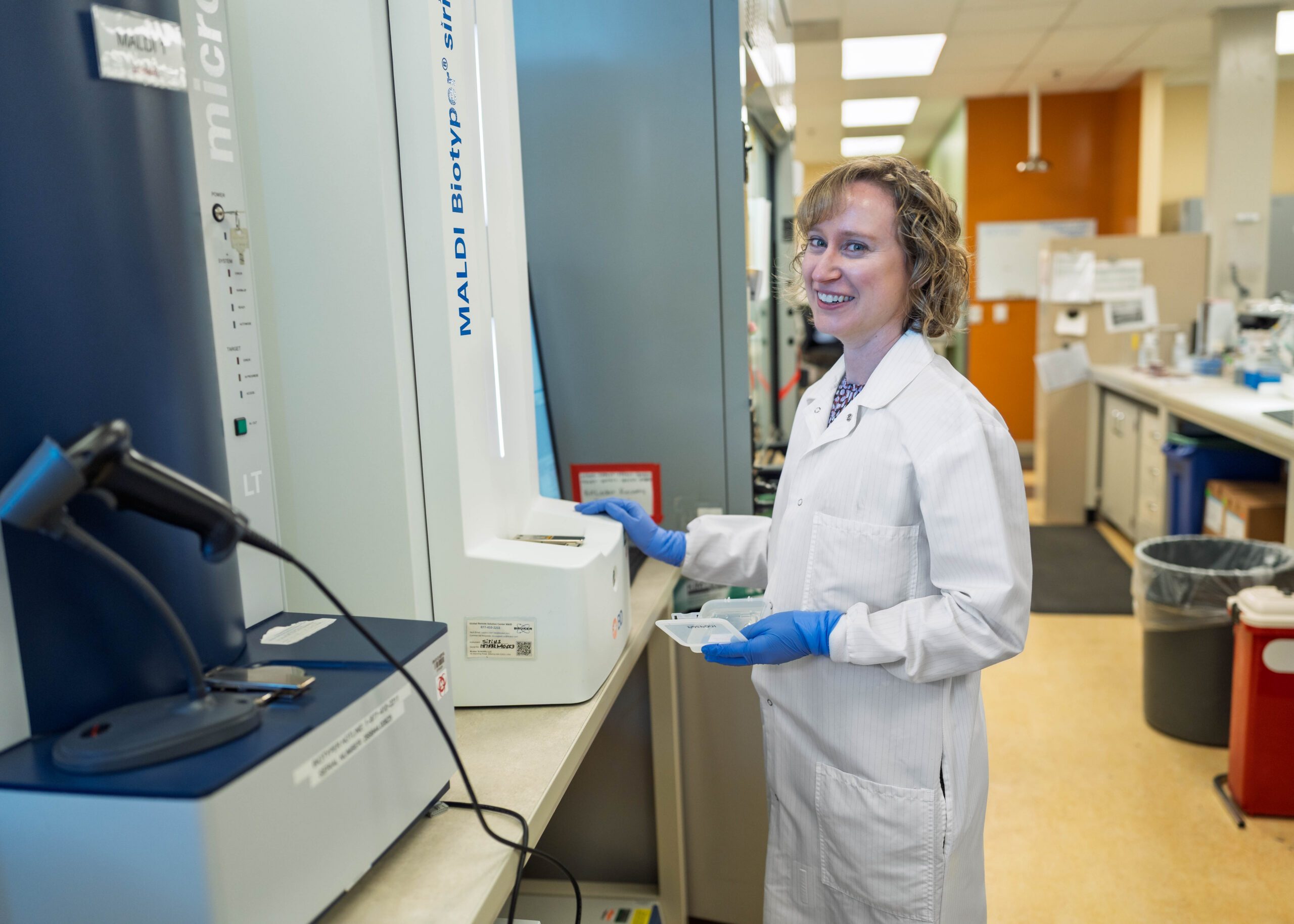 A laboratory scientist working in a hospital lab in a white coat.